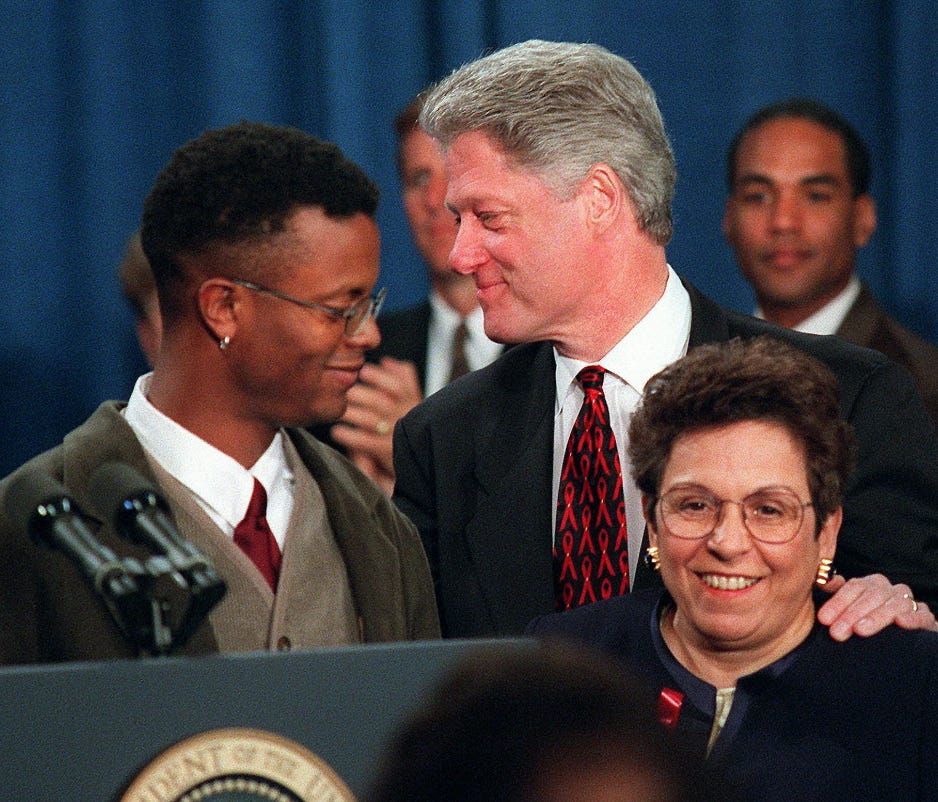 President Clinton greets HIV-positive activist Sean Sasser during the first White House conference on AIDS Dec. 6, 1995, at the Treasury Department in Washington. Health and Human Services Secretary Donna Shalala is at right.