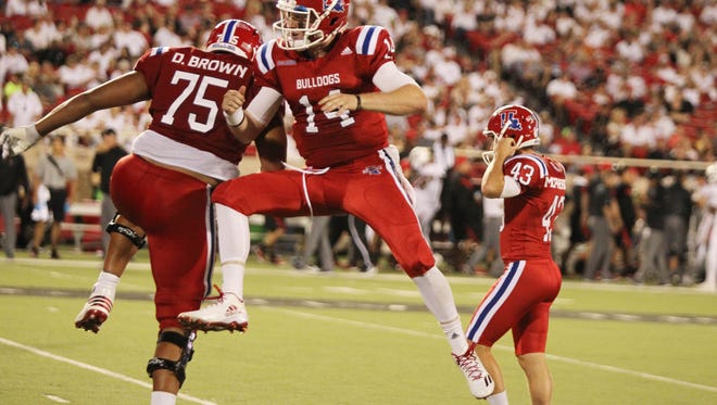 Louisiana Tech Bulldogs quarterback Ryan Higgins (14) and offensive lineman Darrell Brown (75) celebrate scoring a touchdown against the Texas Tech Red Raiders in the second half at Jones AT&T Stadium. Texas Tech defeated Louisiana Tech 59-45.  Mandatory Credit: Michael C. Johnson-USA TODAY Sports