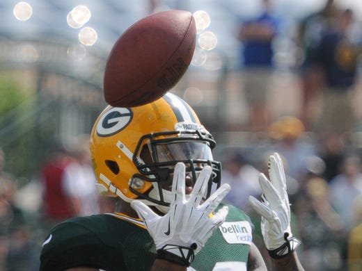 Green Bay Packers linebacker/defensive end Mike Neal reaches for the ball during training camp practice at Ray Nitschke Field, Thursday, July 31, 2014.