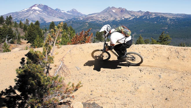 In this Sept. 4, 2013 photo, Tom Lomax rides around one of the wide banked turns on the Lava Flow Trail at the new Mount Bachelor downhill bike park in Bend.
