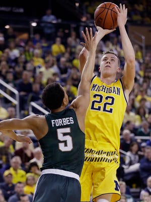 Michigan guard Duncan Robinson (22) shoots over Michigan State guard Bryn Forbes (5) during the first half of an NCAA college basketball game, Saturday, Feb. 6, 2016 in Ann Arbor.