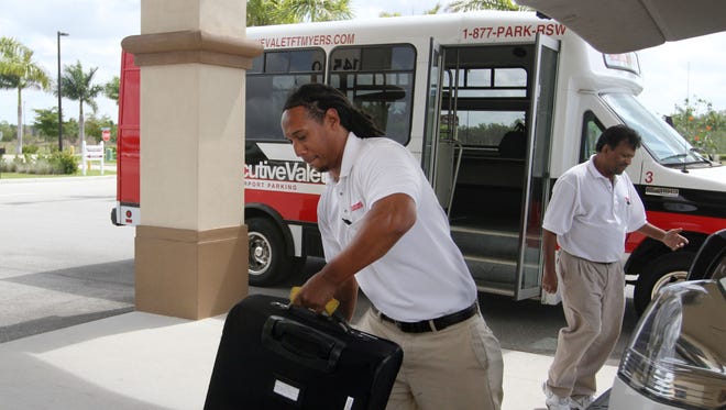 Brandon Jones picks up some baggage for a customer at Executive Valet Parking Thursday morning 5/3/12.  The parking facility is an off-site operation that provides shuttle bus transportation to and from the airport and personalized valet parking of cars.
