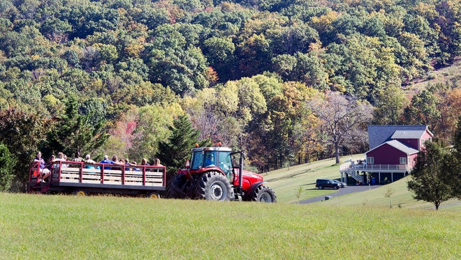 People roll along York Township hills changing for the season during a hay ride at the Wyndridge Farm Fall Festival in York Township.