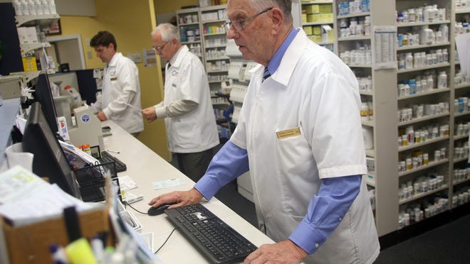 
Bayshore Pharmacy founder Richard C. Stryker, right, works behind the counter with co-owners Richard P. Stryker, left, and Scott Eagelton, center. The Atlantic Highlands pharmacy is 50 years old.
