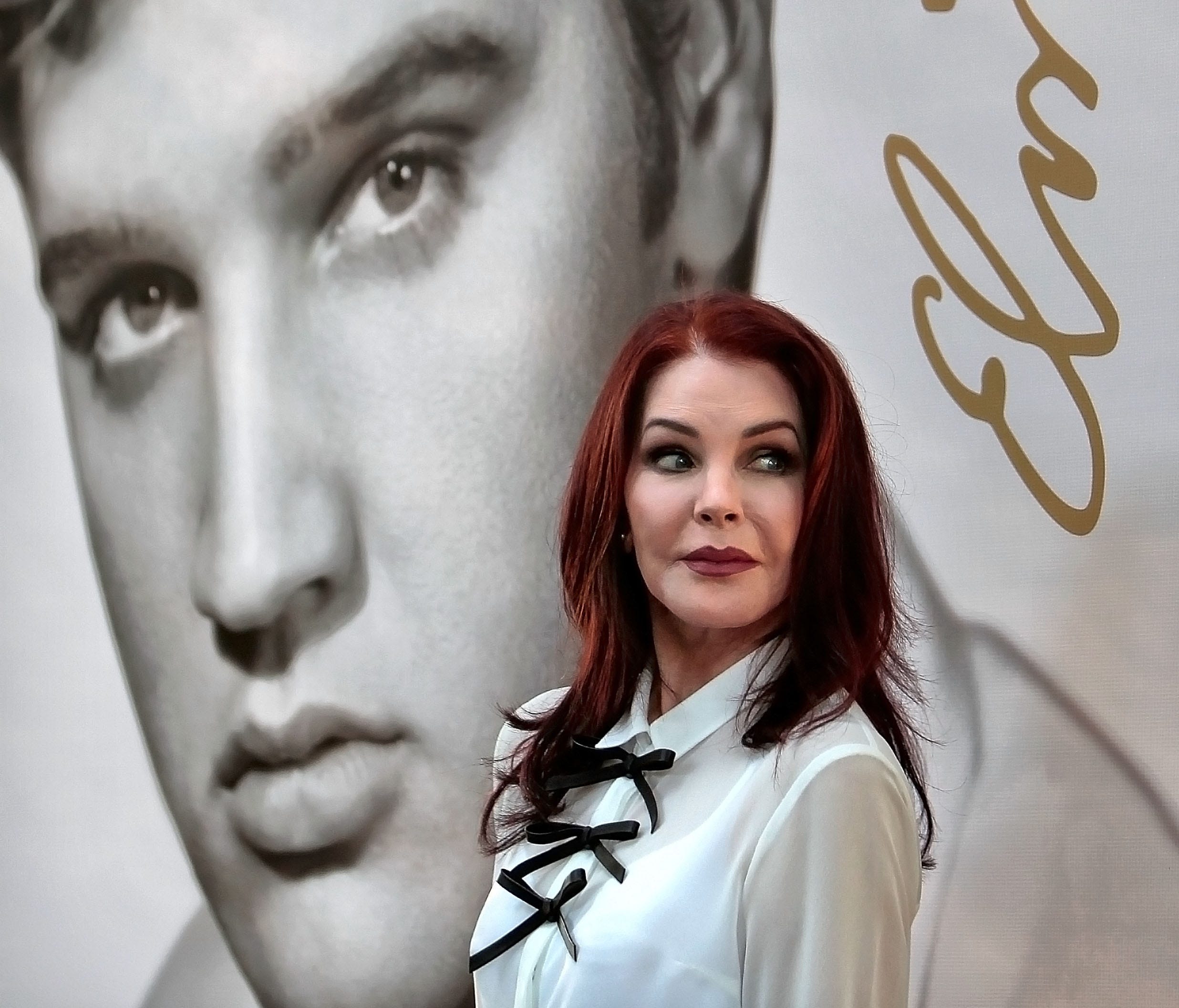 Priscilla Presley glances at a crowd of fans after the dedication ceremony for the new Elvis Forever stamp, the second postal stamp for the music icon Wednesday, Aug. 12, 2015, in Memphis.