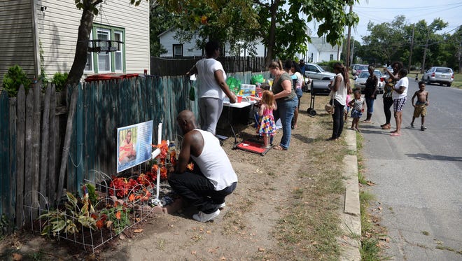 Sean Reid of Newark (left), brother of Jerame Reid, kneels in front of a memorial to his brother during the Bridgeton Justice Alliance barbecue in memory him, Sunday, Aug. 30, 2015 in Bridgeton.  Sean M. Fitzgerald/Staff Photographer