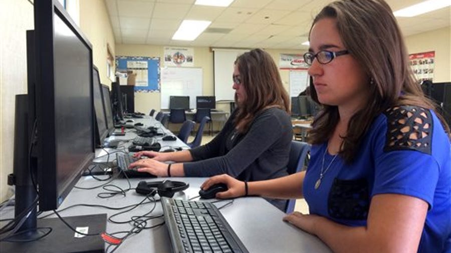 In this April 30, 2015 photo, Leticia Fonseca, 16, left, and her twin sister, Sylvia Fonseca, right, work in the computer lab at Cuyama Valley High School after taking the new Common Core-aligned standardized tests in New Cuyama, Calif. The Cuyama Joint Unified School District is 60 miles from the nearest city and has Internet connections about one-tenth the minimum speed recommended for the modern U.S. classroom. Across the country, school   districts in rural areas and other pockets with low bandwidth are confronting a difficult task of administering new Common Core-aligned standardized tests to students online.