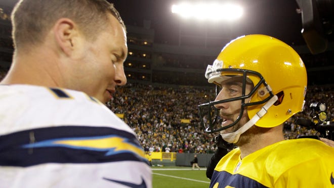 Green Bay Packers quarterback Aaron Rodgers and San Diego Chargers quarterback Philip Rivers meet on the field after their Week 6 matchup.