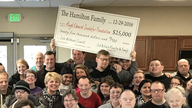 Members of the Hamilton Family, in back, pose with employees and clients of the Sandefur Center.