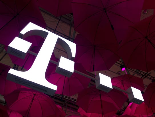 A T-Mobile logo hangs under pink umbrellas at the stand