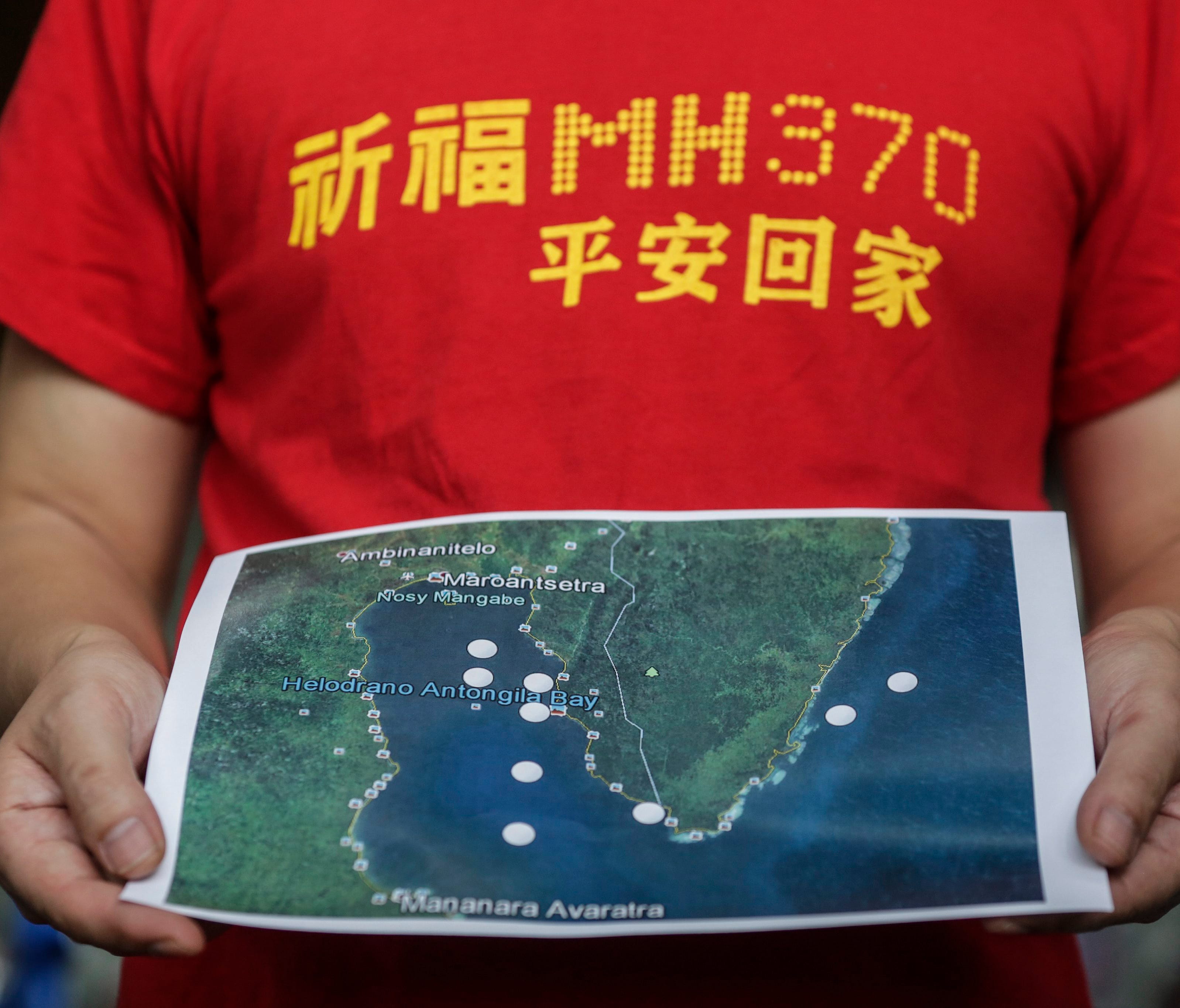 MH370 next-of-kin Jiang Hui from China holds a map during a press conference at Kuala Lumpur International Airport in Sepang, Malaysia, Dec. 3, 2016, before their trip to Madagascar.
