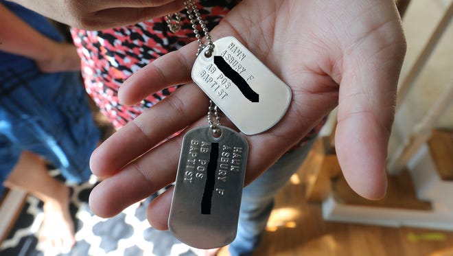 Angie Hawn holds the dog tags that belonged to her late husband, Sgt. Asbury Hawn, who was killed in Iraq in 2005. The tags were stolen and returned to a Goodwill store in Mt. Juliet, and ultimately, the family.