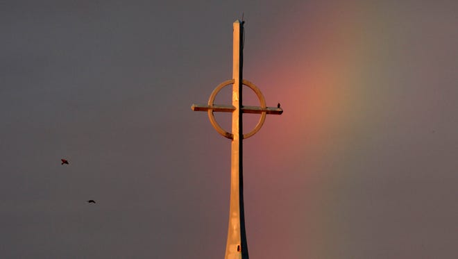 A rainbow is seen behind the steeple of the First Presbyterian Church in Monroe.