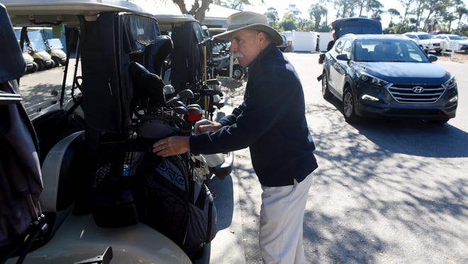 Hank Emery places a customer's golf bag on a cart Thursday, March 15, 2018 at Sandridge Golf Club in Vero Beach. Emery and fellow staff will meet golfers at their cars and transport their bags to a cart and then move the cart to the practice putting green. "You don't get this kind of service at most courses unless you're at a private club," Emery said. "I think this is one of the things that sets us apart from other municipal courses."