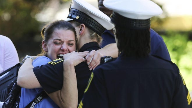 In this Sept. 6, 2018, file photo, a woman is comforted by authorities stationed outside the University of Cincinnati Medical Center's Emergency room following a shooting in downtown Cincinnati that left at least four dead and several injured in Cincinnati.