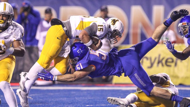 Quarterback Nick Smith of the Wyoming Cowboys and linebacker Ben Weaver of the Boise State Broncos meet at the goal line during second half action on October 24, 2015, at Albertsons Stadium in Boise, Idaho. (Photo by Loren Orr/Getty Images)