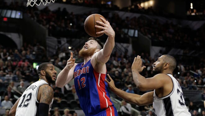 Detroit Pistons center Aron Baynes (12) drives to the basket between San Antonio Spurs defenders LaMarcus Aldridge, left, and Boris Diaw (33)during the first half of an NBA basketball game, Wednesday, March 2, 2016, in San Antonio.
