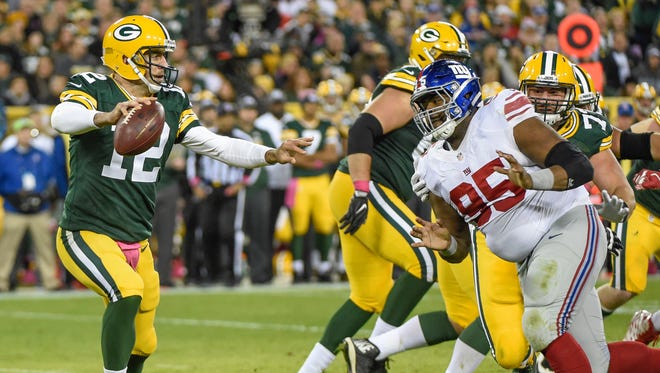 Oct 9, 2016; Green Bay, WI, USA;  Green Bay Packers quarterback Aaron Rodgers (12) looks to pass while getting pressure from New York Giants defensive tackle Johnathan Hankins (95) in the third quarter at Lambeau Field. Mandatory Credit: Benny Sieu-USA TODAY Sports