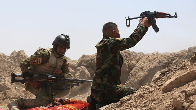 Iraqi soldiers fire towards Islamic State as they attempt to re-take Ramadi, Iraq.