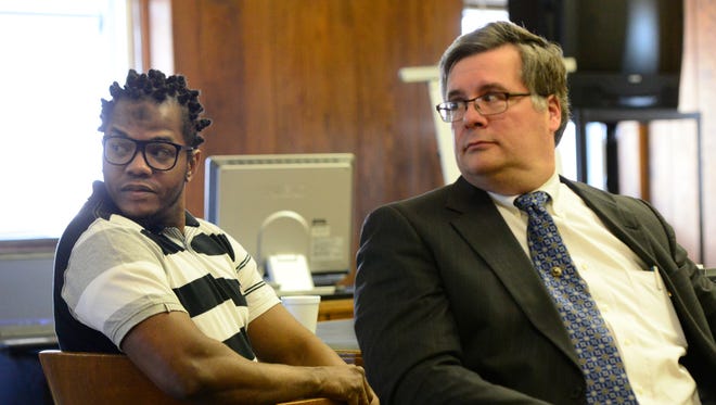 Omar Satchel, left, with then attorney Tim Braun, was found guilty in March 2016 on possessing a weapon while on parole in Michigan.