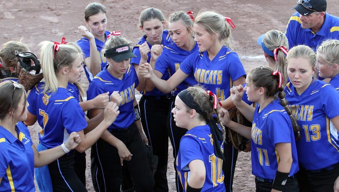 Benton's softball team gathers between innings in their state tournament game against Davenport Assumption.
