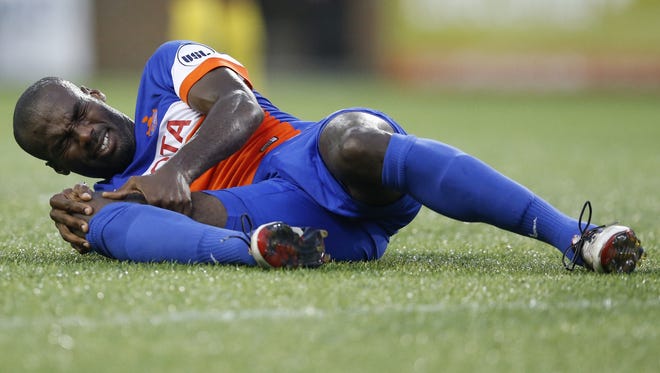 FC Cincinnati forward Omar Cummings (14) holds his knee after a collision in the first half during the USL soccer game between the Rochester Rhinos and FC Cincinnati, Wednesday, Aug. 24, 2016, at Nippert Stadium in Cincinnati.