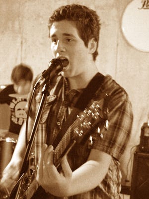 Chris Mandel plays rhythm guitar and sings during a Cross the Line’s rehearsal.