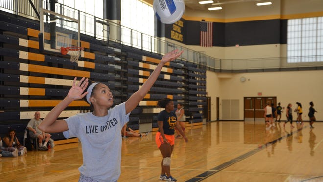 Battle Creek Central’s Aaliyah Hill serves the ball for a drill during the first volleyball practice of the season on Wednesday.