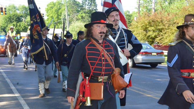 Civil War re-enactors from the First Michigan Volunteer Infantry and the 18th Michigan Infantry Company A march through Marshall on Friday, June 15, 2018.