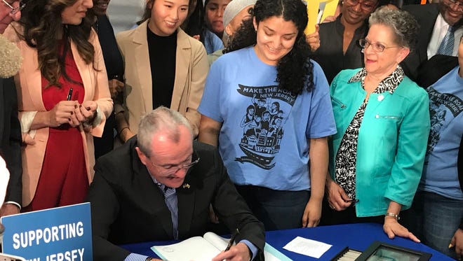 Gov. Phil Murphy signs a bill extending eligibility for financial aid to undocumented students at a ceremony at Rutgers University in Newark on Wednesday.