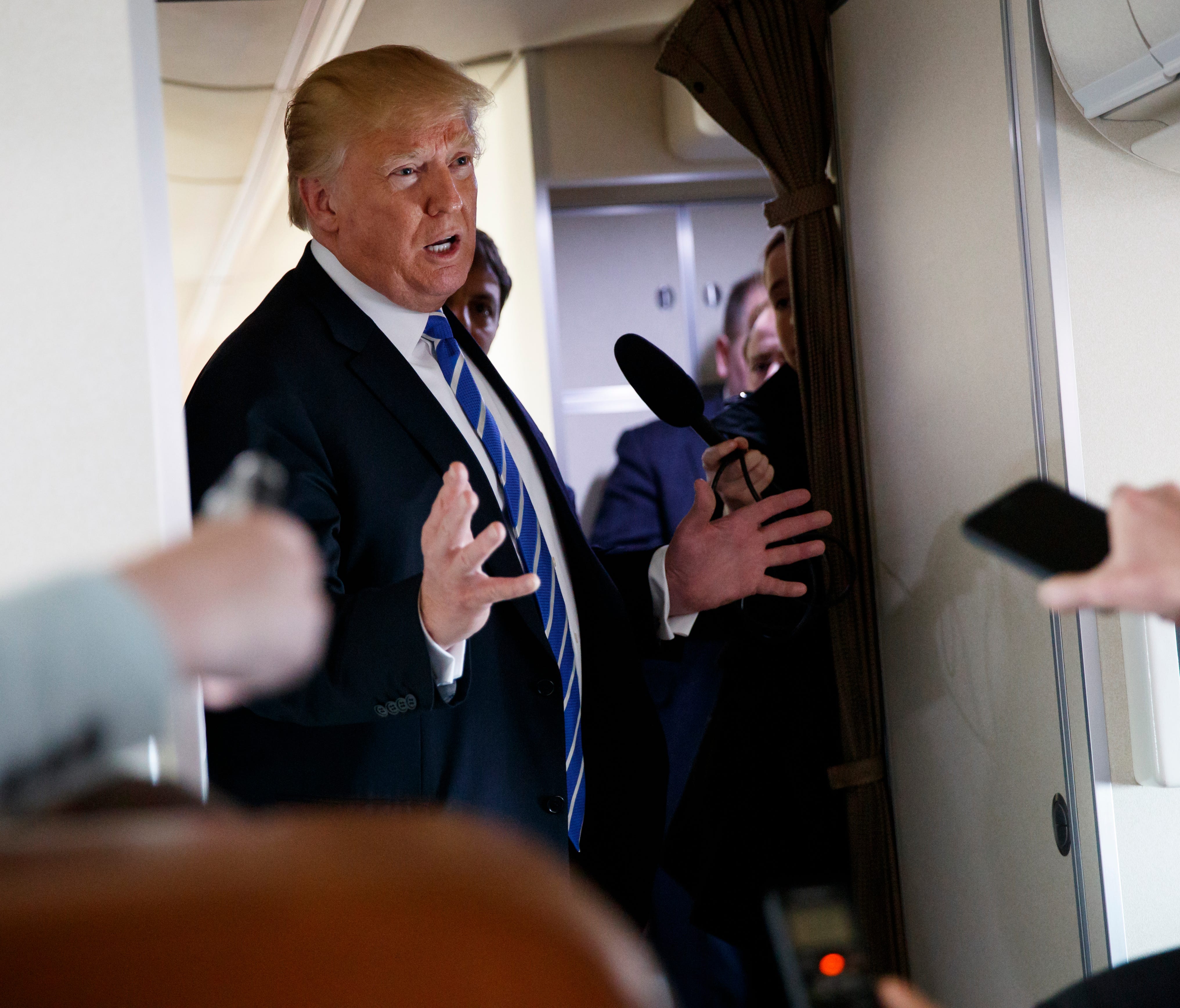 President Trump talks with reporters aboard Air Force One on a flight to Andrews Air Force Base, Md.,, Thursday.