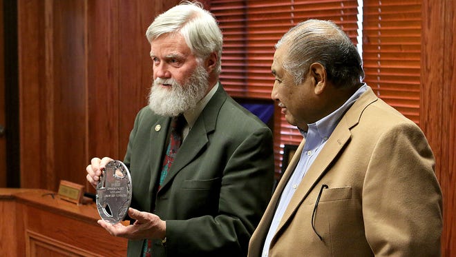 Wichita County Judge Woody Gossum (left) returns a plaque to Ray Gonzalez, retiring county commissioner of Precinct 1, after adding the end date of his service to Wichita County during his retirement party Thursday morning at the Wichita County Commissioners Court.