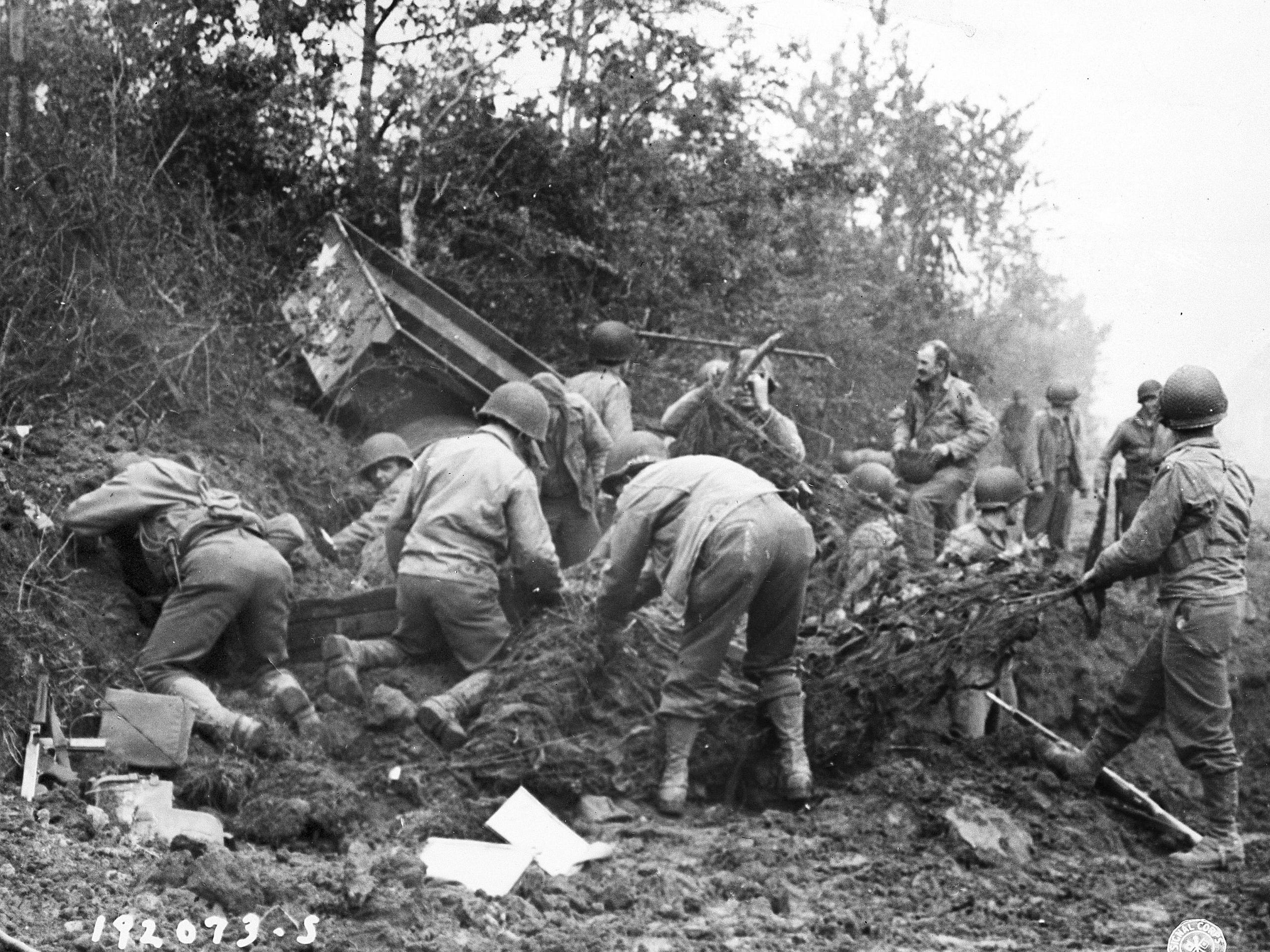 Las tropas estadounidenses comienzan a desenterrar a los hombres enterrados después del bombardeo alemán, el 25 de julio de 1944, en algún lugar de Francia. (Foto AP)