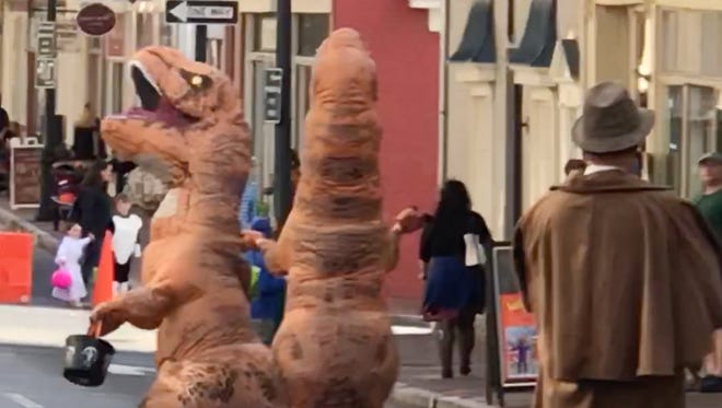 Two dinosaurs dance in the streets of downtown Staunton.