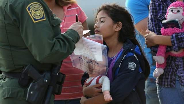 Salvadorian immigrant Stefany Marjorie, 8, watches as a U.S. Border Patrol agent records family information on July 24 in Mission, Texas.