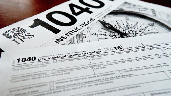 This Feb. 13, 2019, file photo shows multiple forms printed from the Internal Revenue Service web page that are used for 2018 U.S. federal tax returns in Zelienople, Pa. IRS data released Thursday, April 25, shows that while the average refund fell, the tax filing season was largely unchanged by the massive tax overhaul.