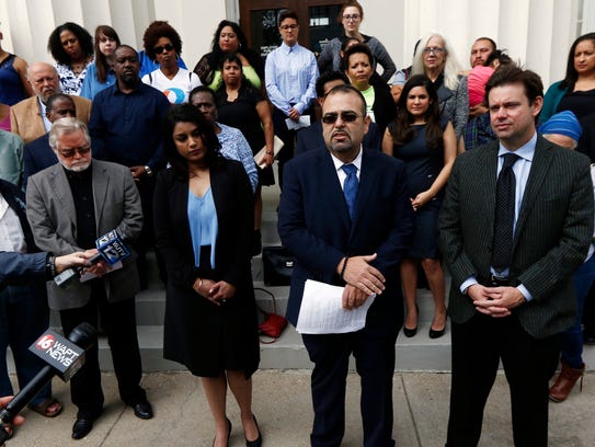 Attorney Ramiro Orozco, center, flanked by fellow immigration