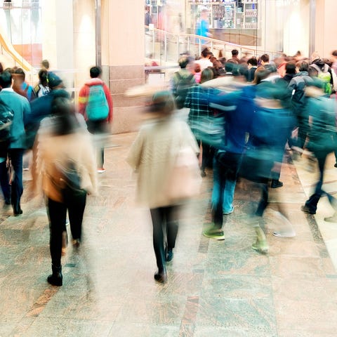 Blurry shoppers filing through a mall.