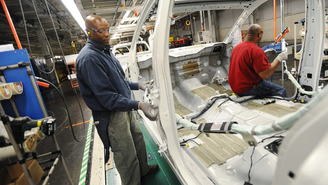 Nissan employee Cleotha Hill works on an Armada SUV as the vehicle passes his station on the assembly line at the company's manufacuring plant in Canton on Wednesday. 