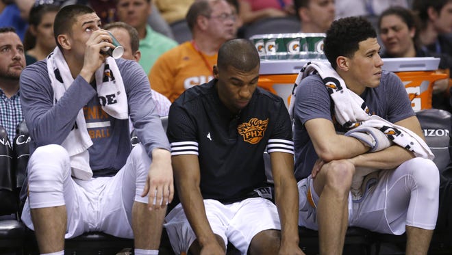 Suns players (from left) Alex Len, Ronnie Price and Devin Booker watch from the bench during the Suns' final game of the season.