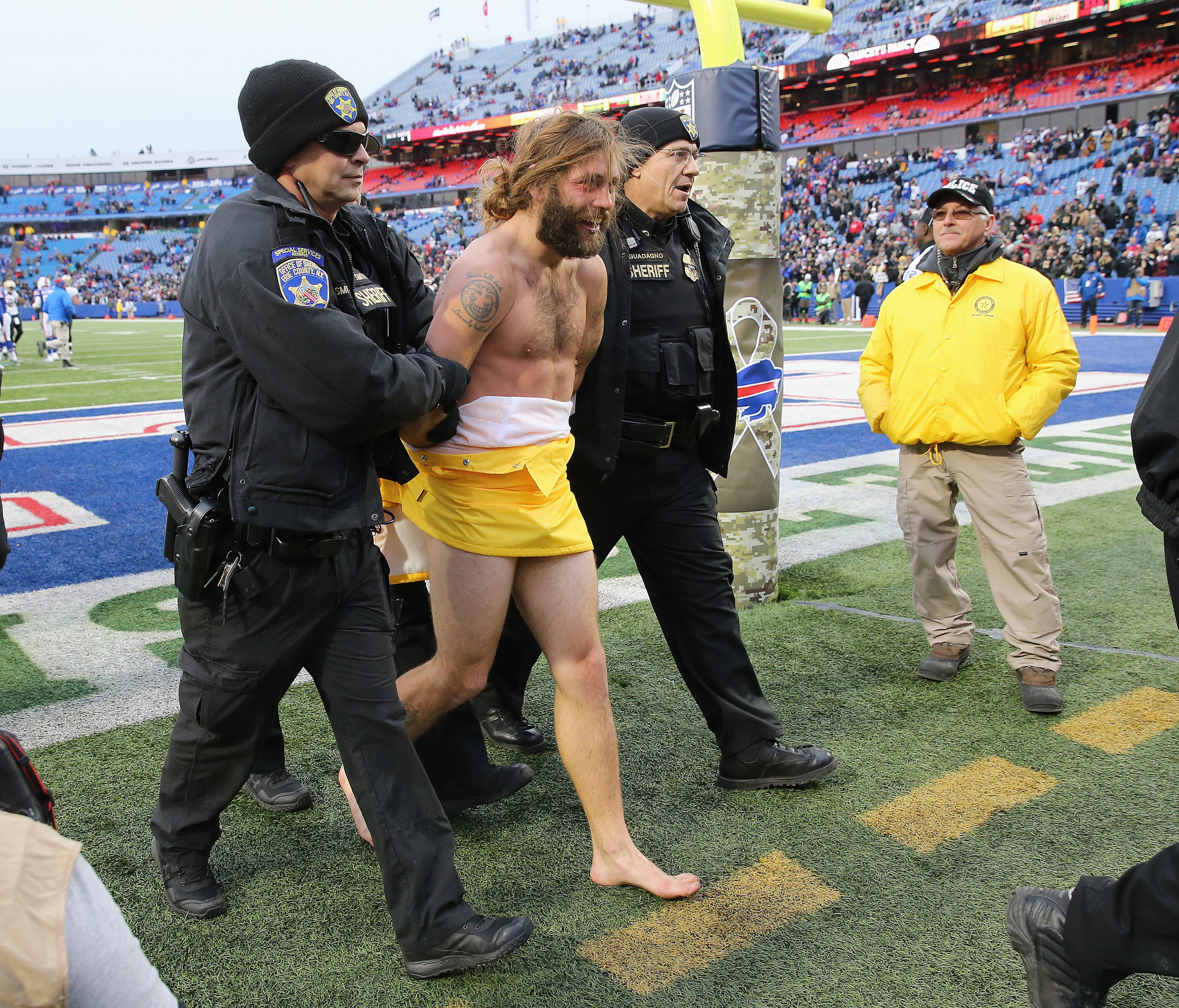 Police escort a streaker who ran onto the field during a 47-10 Bills loss to the Saints.