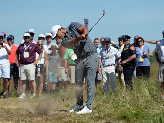 Brooks Koepka hits from the rough on the sixth hole