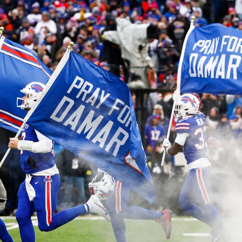 The Buffalo Bills carry flags onto the field displ
