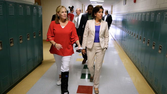 East Providence High School Principal Shani Wallace, left, leads Gov. Gina Raimondo on a tour of the school in August.
