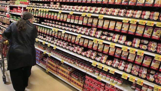 A shopper walks down the canned soup aisle at a grocery store in Cincinnati. Food companies and restaurants could soon face government pressure to make their foods less salty.