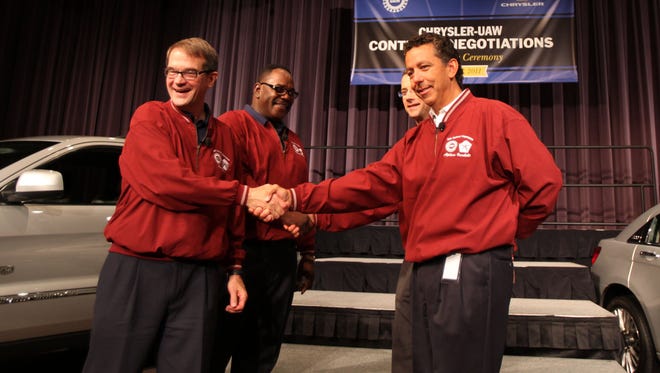 Former UAW President Bob King, left and Former UAW VP General Holiefield, shake hands with Al Iacobelli, vice president of Chrysler Group employee relations, right and Scott Garberding, head of purchasing for Fiat Chrysler Automobiles before UAW-Chrysler contract negotiations on July 25, 2011.