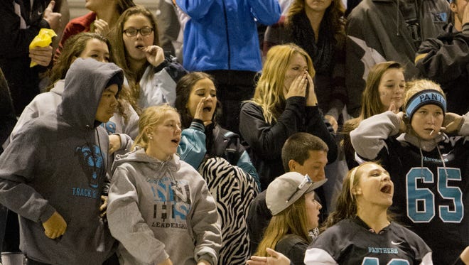 Football fans cheer during a game earlier this season. The Division I North football playoffs start tonight.