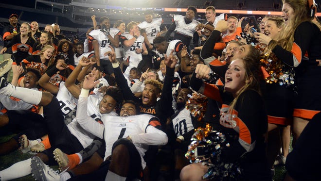 The Cocoa Tigers celebrate their Class 4A state football title Thursday evening in Orlando. 