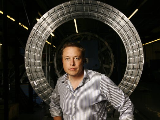 Elon Musk stands in front of parts of the first stage