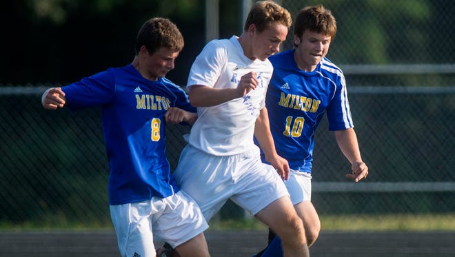 South Burlington's Patrick O'Hara, center, is pressured by Milton's Cam Goodrich, left, and Ryan Collette in South Burlington on Tuesday, September1, 2015.